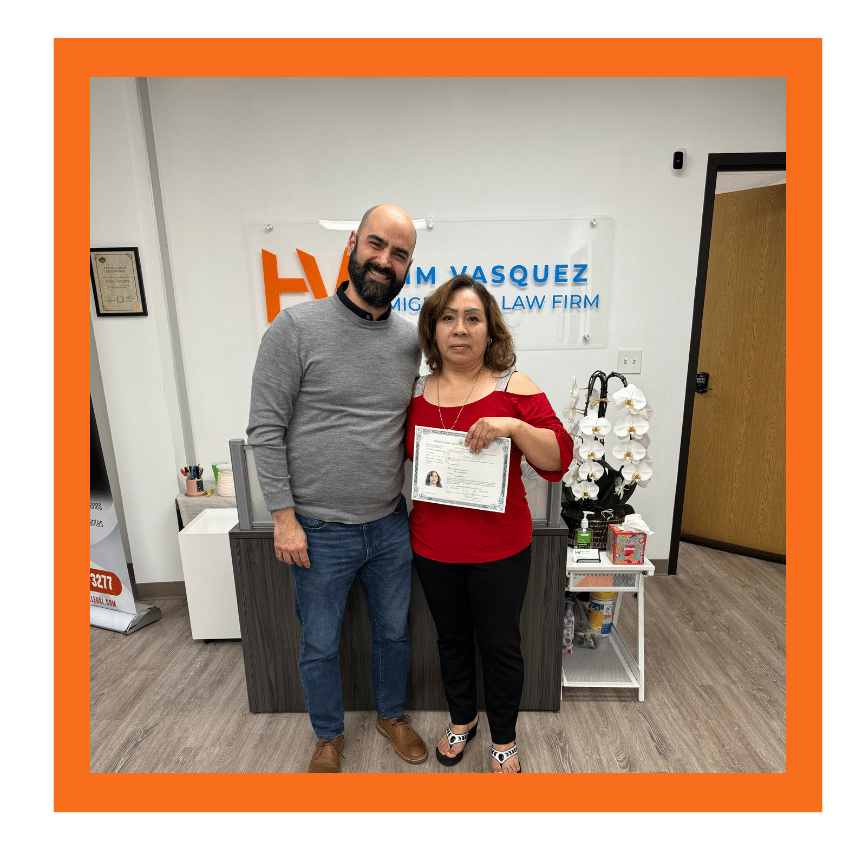 Immigration attorney standing with client holding an approved document