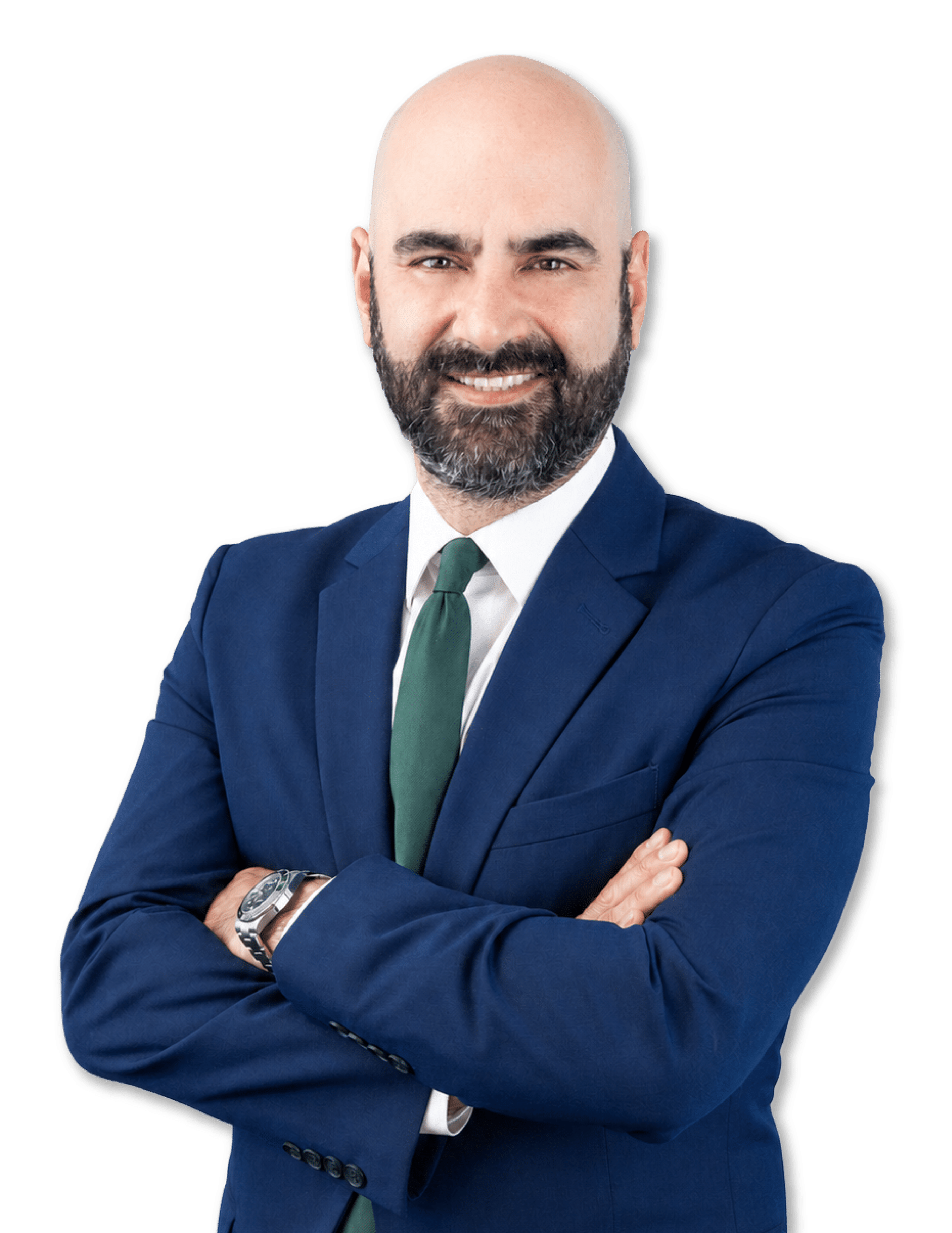 Smiling bald man with a beard in a navy suit and green tie, arms crossed, against a black background.
